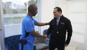 FP1 Smile clinic patient being welcomed with a handshake before dental implant consultation
